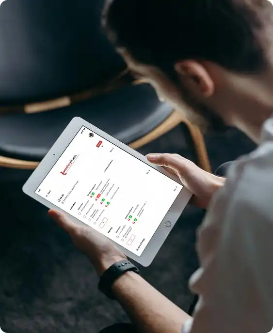 The app in use: someone reviewing a check-in report on a tablet while standing in a property